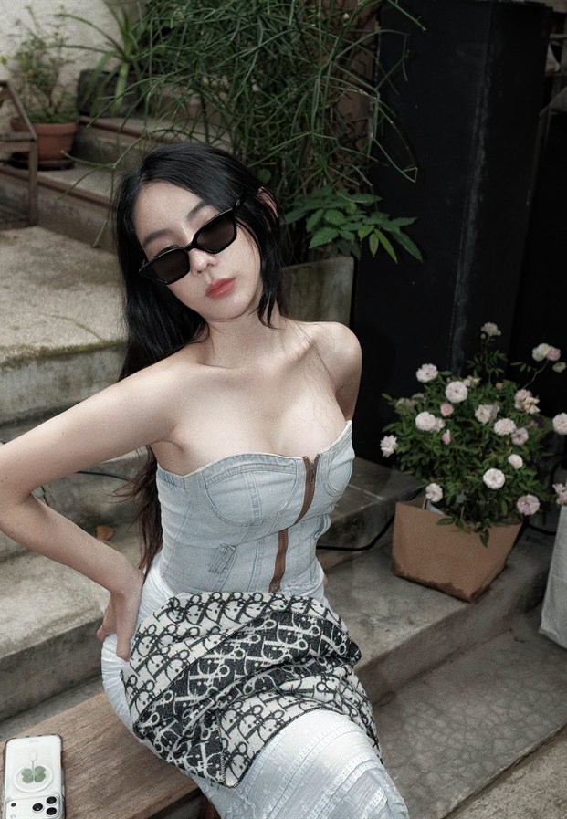Pimnara Kittiwongwan ในชุดคอร์เซ็ตสีขาวนั่งถ่ายริมบันได