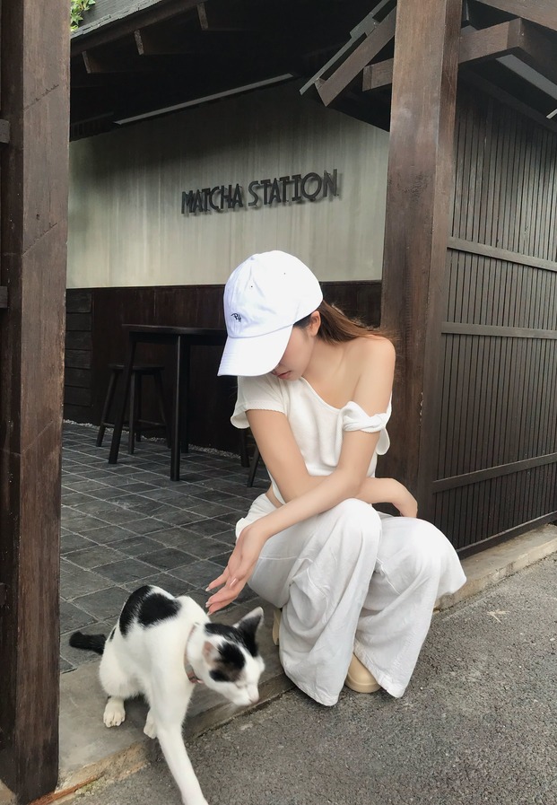 สาวเหนือนั่งเล่นกับแมวหน้าร้านคาเฟ่