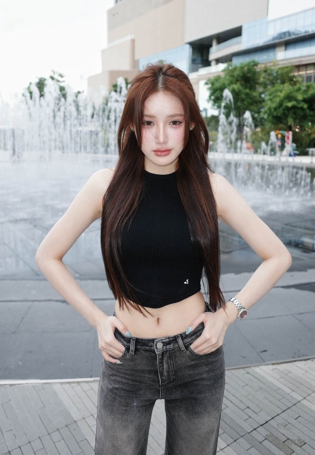 khanomwws ยืนหน้าน้ำพุในเสื้อกล้ามสีดำกับกางเกงยีนส์