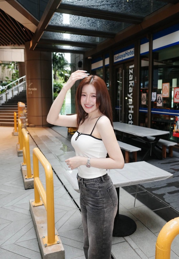 khanomwws ยืนริมทางเดินร้านอาหารในเสื้อสายเดี่ยว