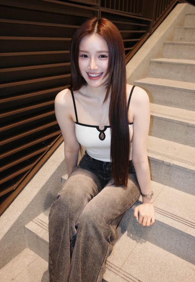 ขนม นั่งบนบันไดในเสื้อสายเดี่ยวสีขาว