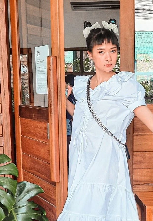 NongBie YARIN ในชุดเดรสสีขาวระบาย ผูกโบว์ใหญ่บนศีรษะ