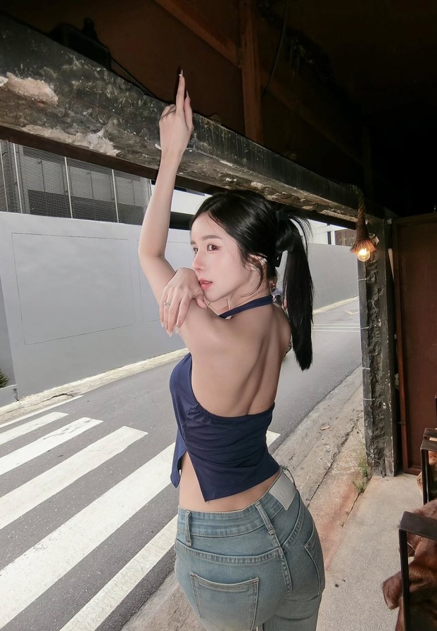 ลุคเสื้อสายคล้องคอสีกรมคู่ยีนส์บนทางม้าลาย