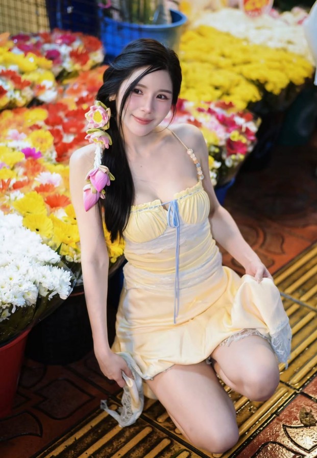 เดรสสีเหลืองนั่งท่ามกลางตลาดดอกไม้สีสด