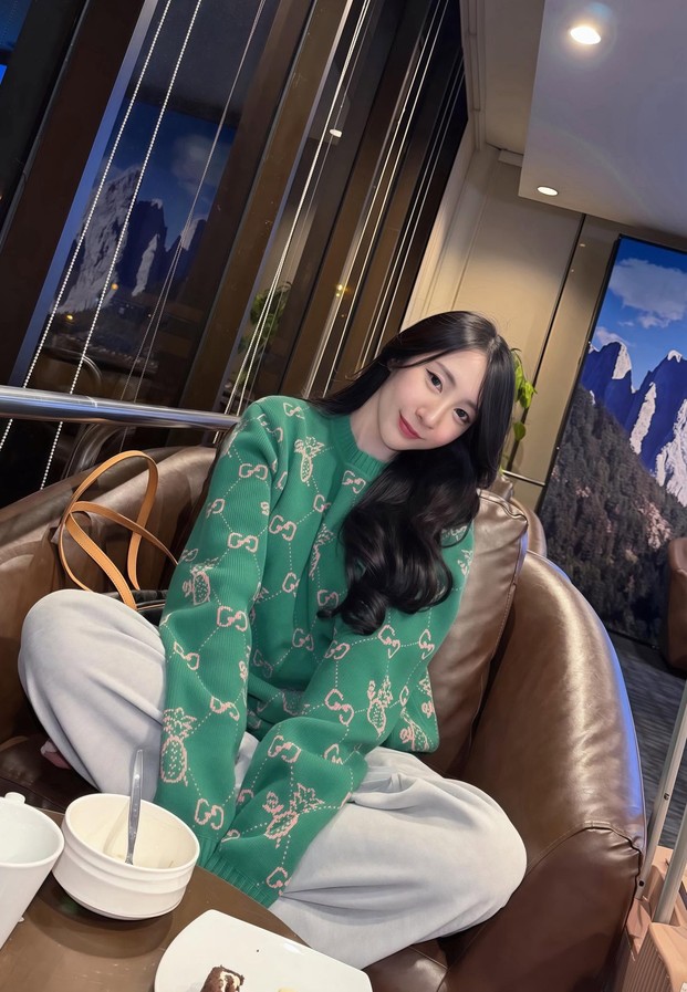 Suneta Ngachalvy ในเสื้อไหมพรมสีเขียวนั่งบนโซฟาหนัง