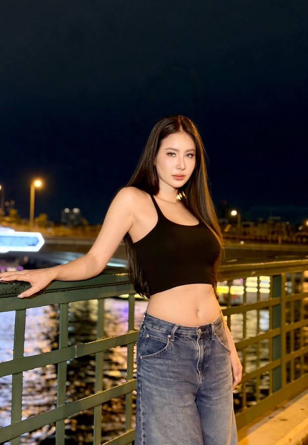 Thanyarat Rodpol ในเสื้อครอปสีดำคู่กางเกงยีนส์บนสะพานสีเขียวยามค่ำ