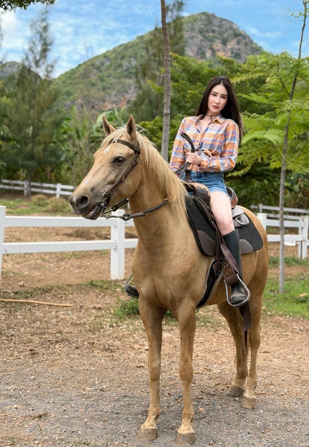 ลุคคาวเกิร์ลเสื้อเชิ้ตลายสก๊อตขี่ม้าสีน้ำตาลท่ามกลางหุบเขา