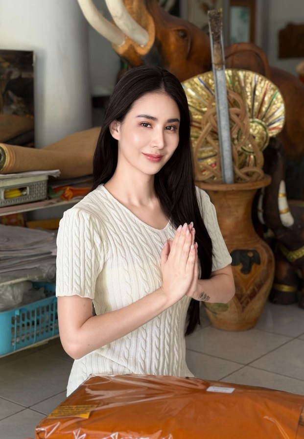 Thanyarat Rodpol ในเสื้อไหมพรมสีขาวพนมมือไหว้พระทำบุญ